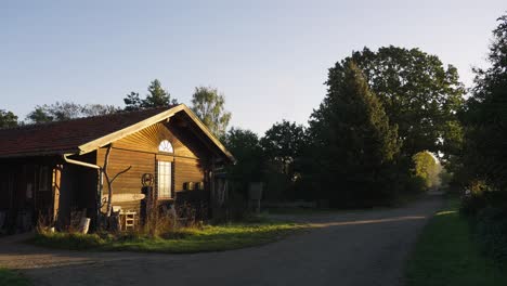 static shot of rural wooden little house in middle of countryside at sunset