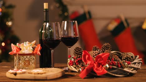 red wine bottle with glass and pine cone