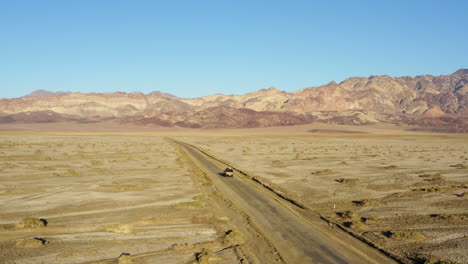 Kamerafahrt-Eines-SUV-Jeeps-Auf-Der-Straße-Inmitten-Des-Heißen,-Trockenen,-Kargen-Geländes-Des-Death-Valley-Nationalparks