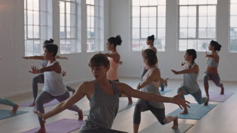 yoga-class-instructor-leading-group-meditation-teaching-healthy-women-warrior-pose-enjoying-exercising-in-fitness-studio-practicing-posture-at-sunrise