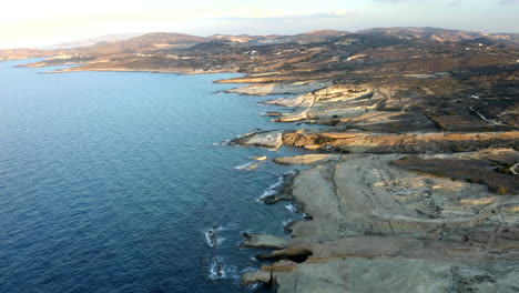 wide angle smooth cinematic aerial drone footage of sarakiniko beach in milos island, greece at sunset in 4k