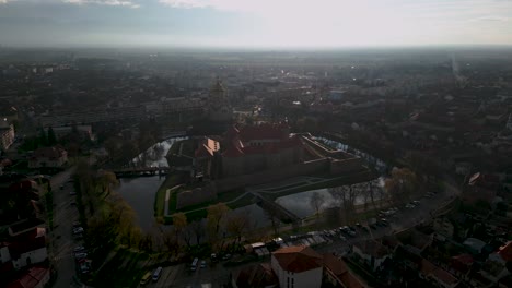 Drone-flight-over-the-castle-of-Fagaras-in-Romania-during-afternoon-with-water-reflections---Autumn-panorama-establishing-shot-of-city-of-Făgăraș-in-România---Transylvania-region-2022