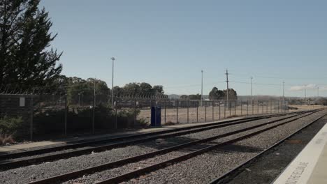 train yard scene with tanker carriages seen from the platform at canberra station