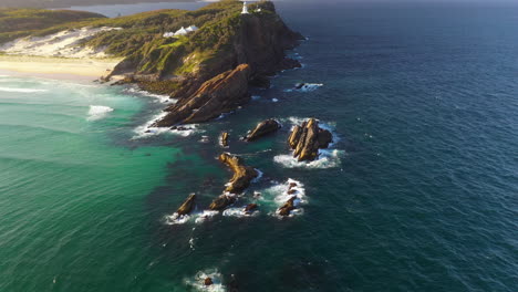 aerial: lighthouse on clifftop of rugged australia coastline, tilt up reveal