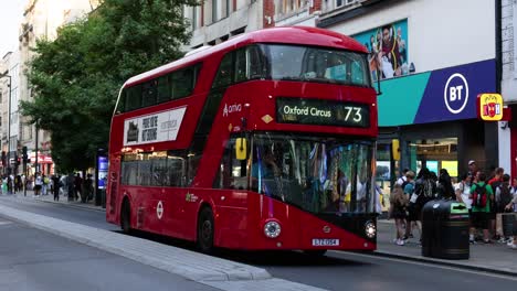 red double-decker bus traveling through busy london street