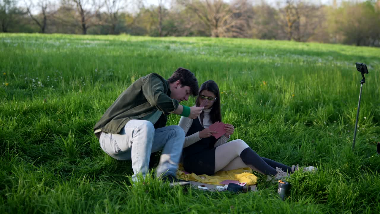 Young Adults Playing Cards in a Park