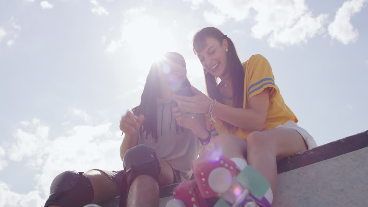 전화를 사용하는 인종 간 스케이터 친구들