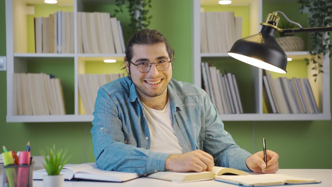 un estudiante feliz sonríe a la cámara.