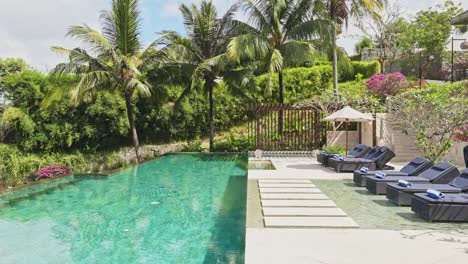 complejo de lujo de 5 estrellas en bali, indonesia con piscina infinita rodeada de palmeras