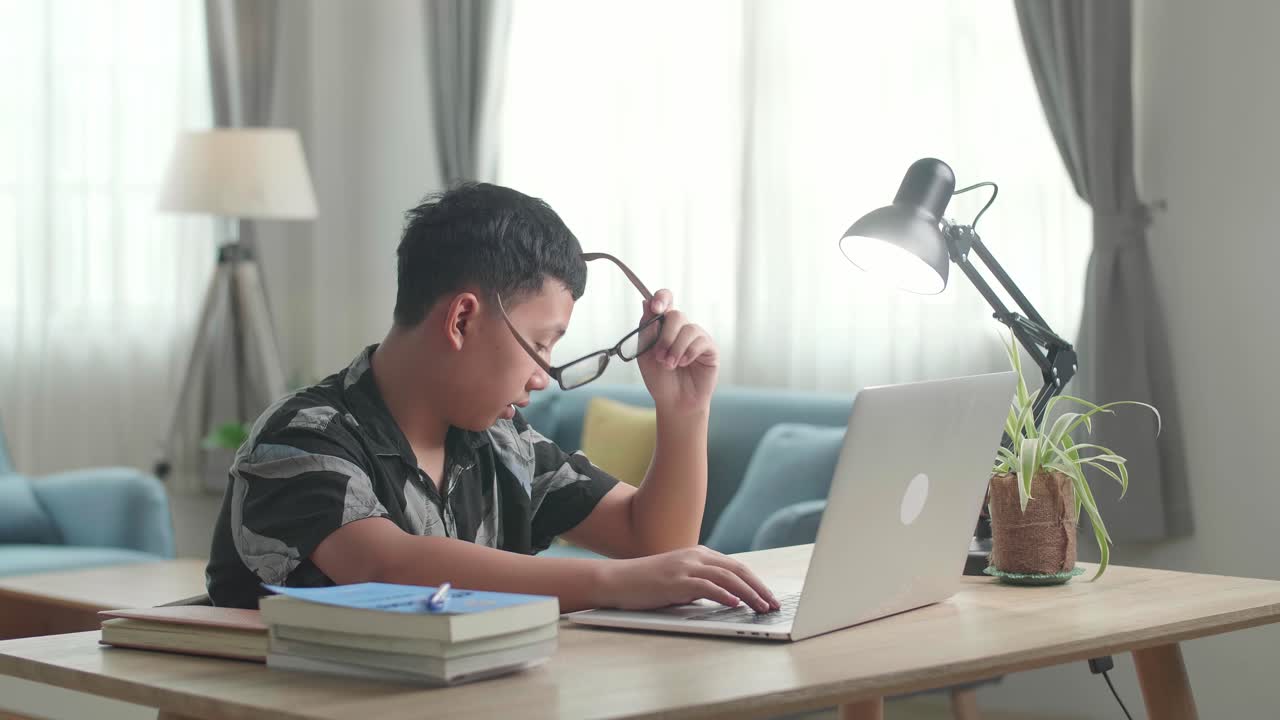 Tired Teenage Boy Sleeping On The Table At Home After Doing Home Work