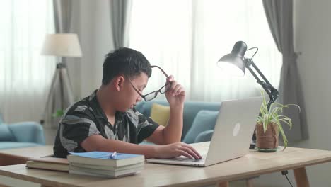 tired teenage boy sleeping on the table at home after doing home work