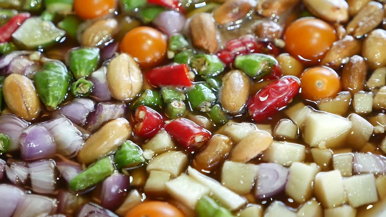 태국식 야자 설탕 소스, 칠리, 땅콩, 생강, 샬롯이 섞인 달콤하고 매운 소스의 클로즈업 영상, 주로 튀긴 생선과 함께 제공