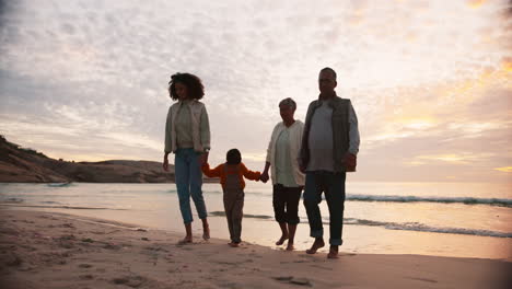 familia, caminando por la playa con viajes