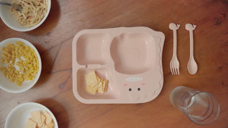 filling additional corn on a kids plate on top of the table