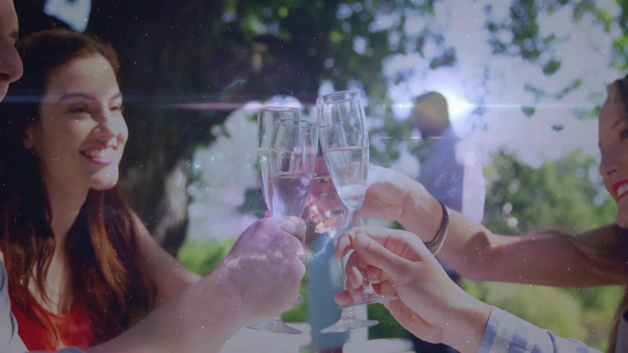Guests raising flutes, hands bringing them at outdoor celebration, cosmic overlay shimmering