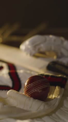 cricket still life with close up of bat ball gloves stumps jumper and bails lying on wooden surface in locker room 3