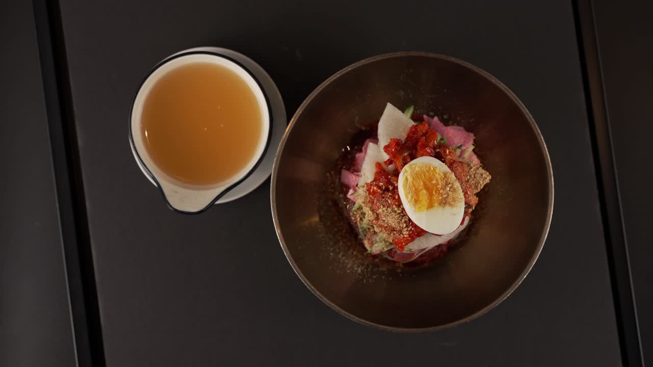 Chilled chewy noodles with savory pollock and a zesty seasoning. 고소한 명태와 새콤한 양념이 조화로운 차가운 쫄깃한 면.