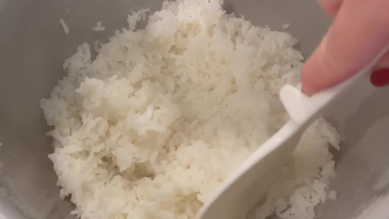 arroz blanco pegajoso de grano corto al vapor en la olla arrocera