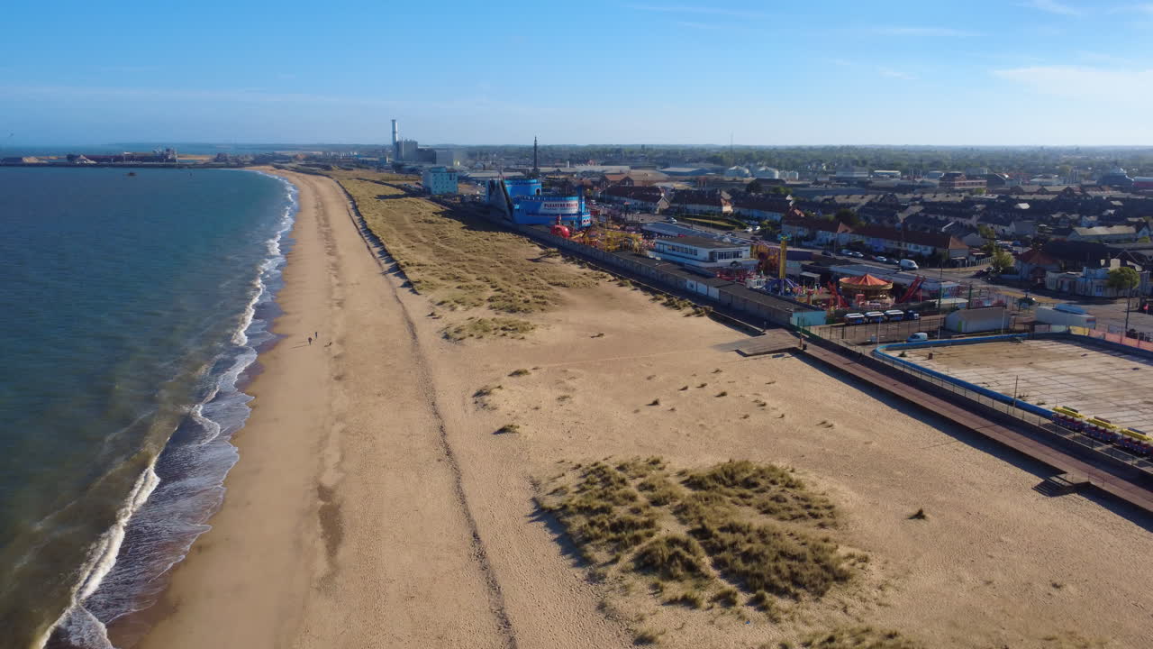 Great Yarmouth port, England. Rising shot showing the port, residential areas, some empty amusements, the waterfront, and houses along the Norfolk coastline in a quiet, historical industrial setting