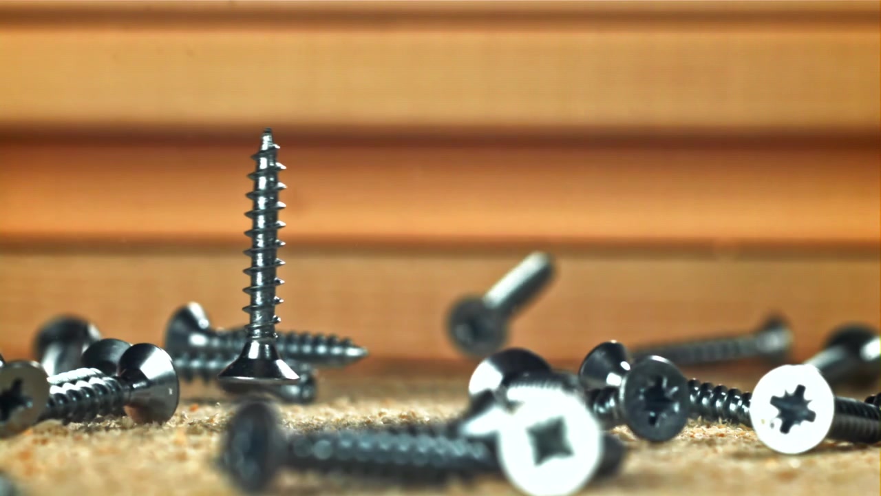 Slow Motion of Screws Falling onto Wood and Sawdust