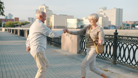 happy senior couple dancing outdoors