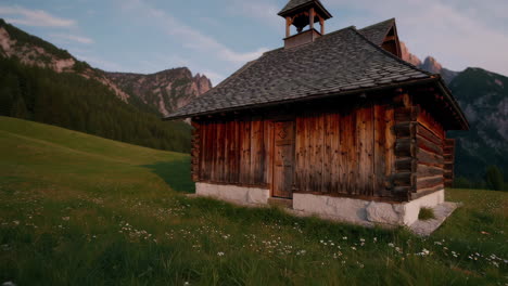 alpine chapel in a mountain meadow at sunset