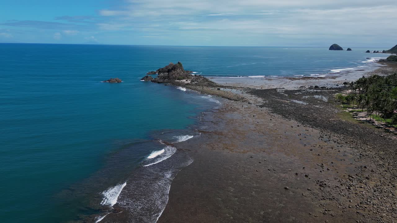 A sweeping wide-angle drone shot captures the vast expanse of the shoreline