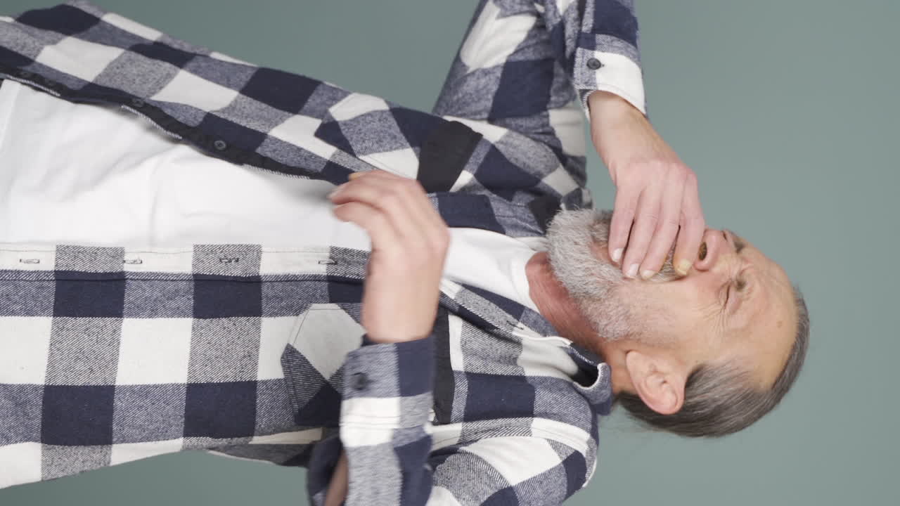 vídeo vertical de un anciano somnoliento bostezando.