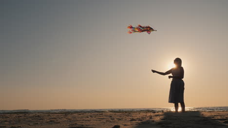 side view - silhouette of a young woman with a kite