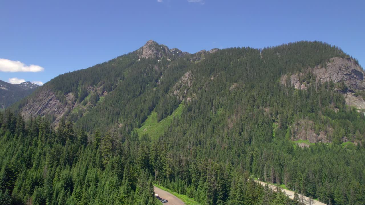 Aerial View of a Mountain Road Winding Through a Lush Green Forest