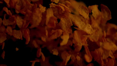 Cereal-flakes-bouncing-against-black-background