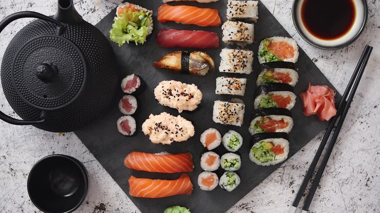 assortimento di diversi tipi di involtini di sushi posizionati su tavola di pietra nera