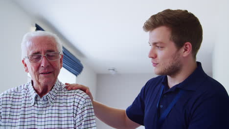 male nurse talking to senior man at home, close up