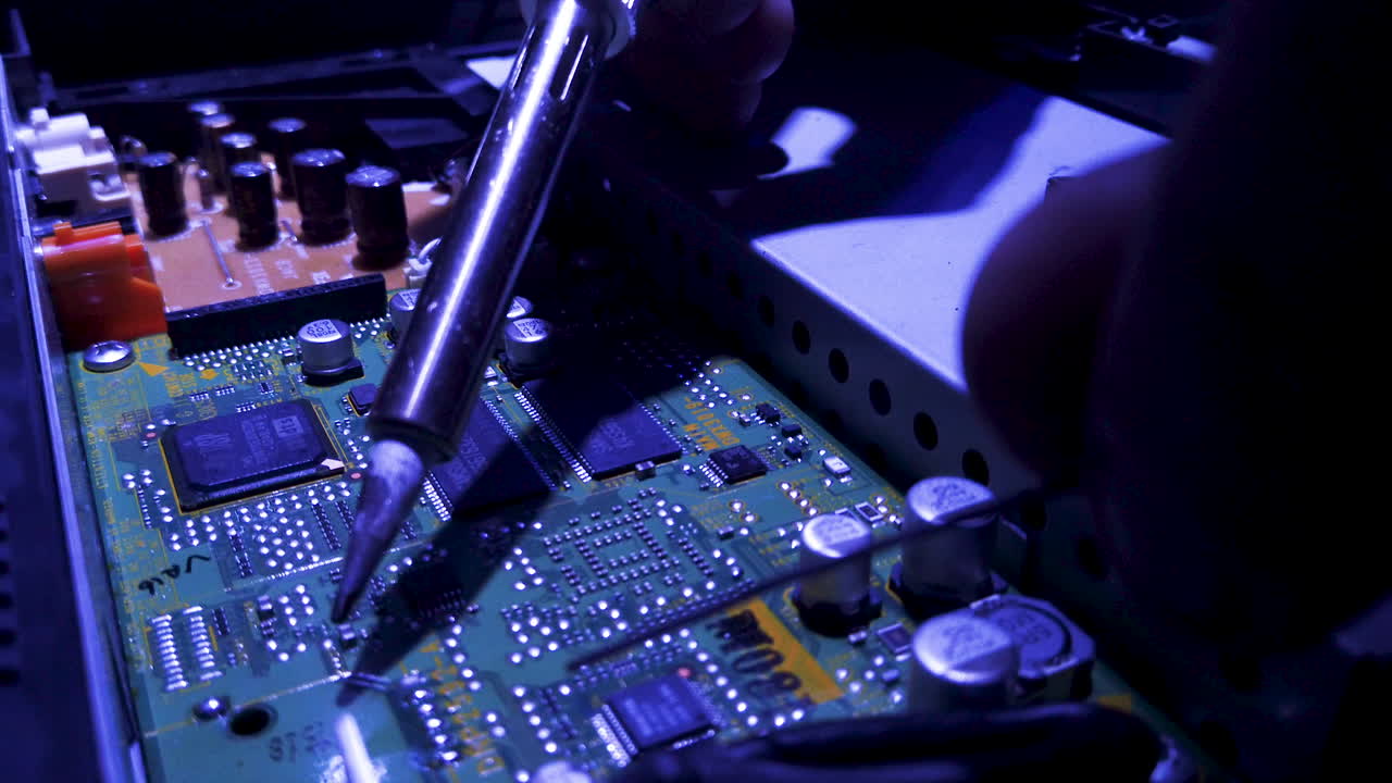 Soldering an electronics computer motherboard.