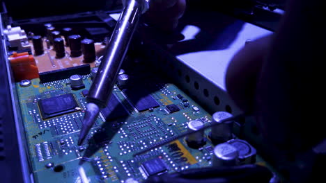 soldering an electronics computer motherboard.
