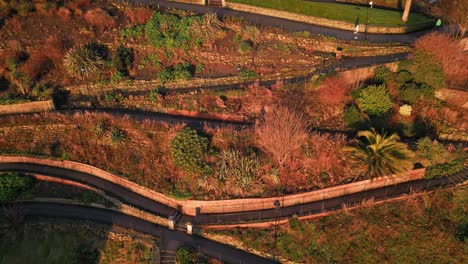 Aerial-backward-shot-of-a-old-beautiful-city-situated-at-a-high-ground-with-greenery-all-over-it-in-Scarborough-North-Yorkshire,-England-during-summer