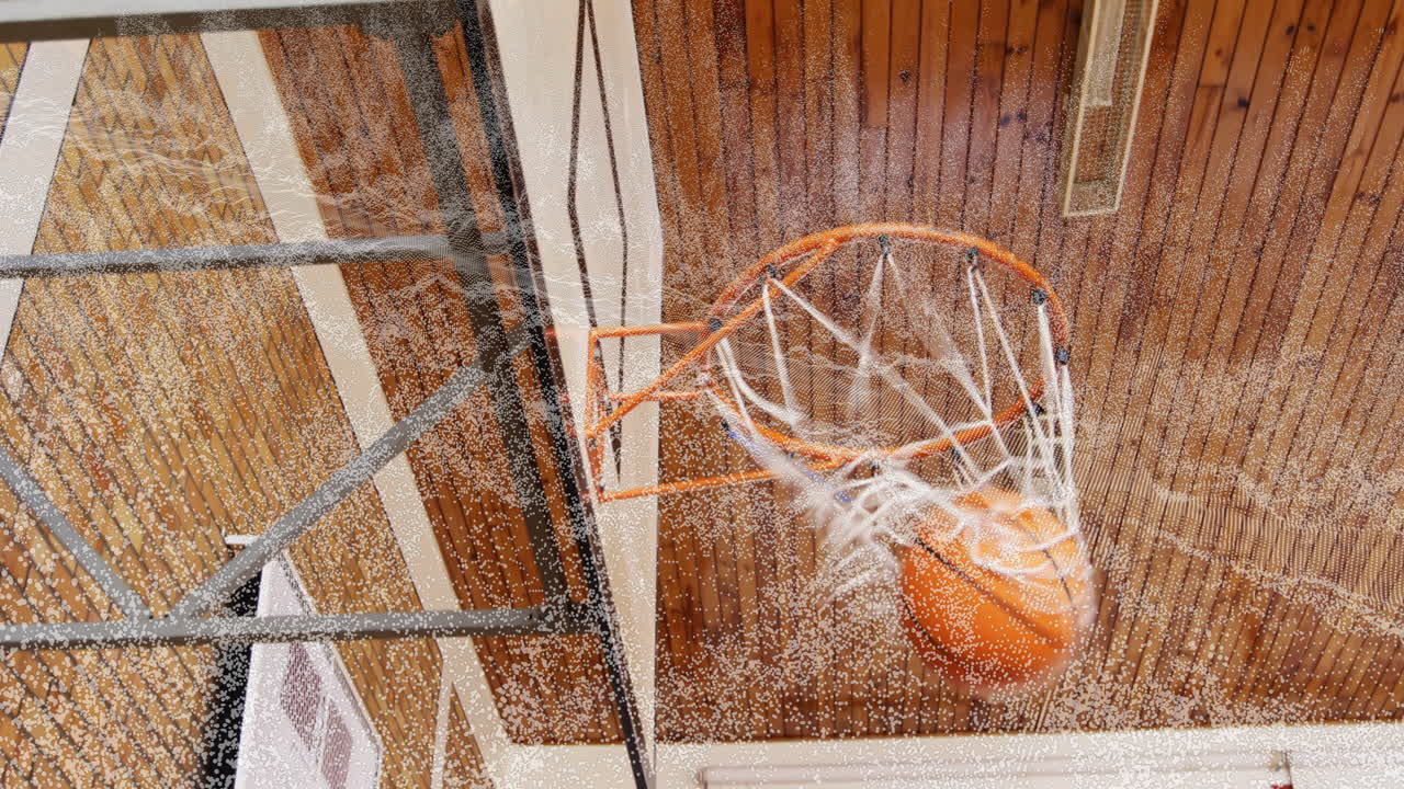 Animation of basketball swishing through hoop in school gym with wooden ceiling