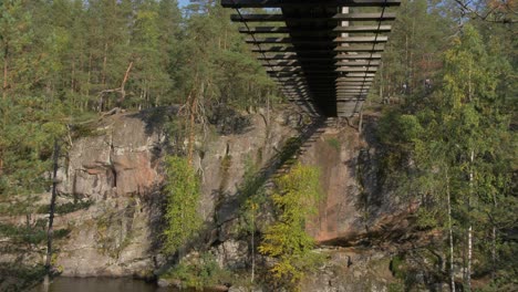 floating bridge on ropes over a lake or a stream in a forest, summer