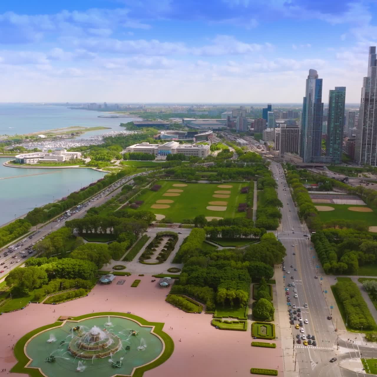 Wonderful big green park with fountain in the middle. Amazing scenery of the city at the waterfront of the lake