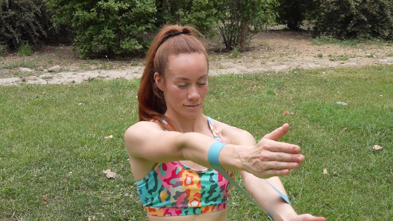 Una giovane donna si allena con fasce di resistenza in un parco promuovendo fitness e benessere