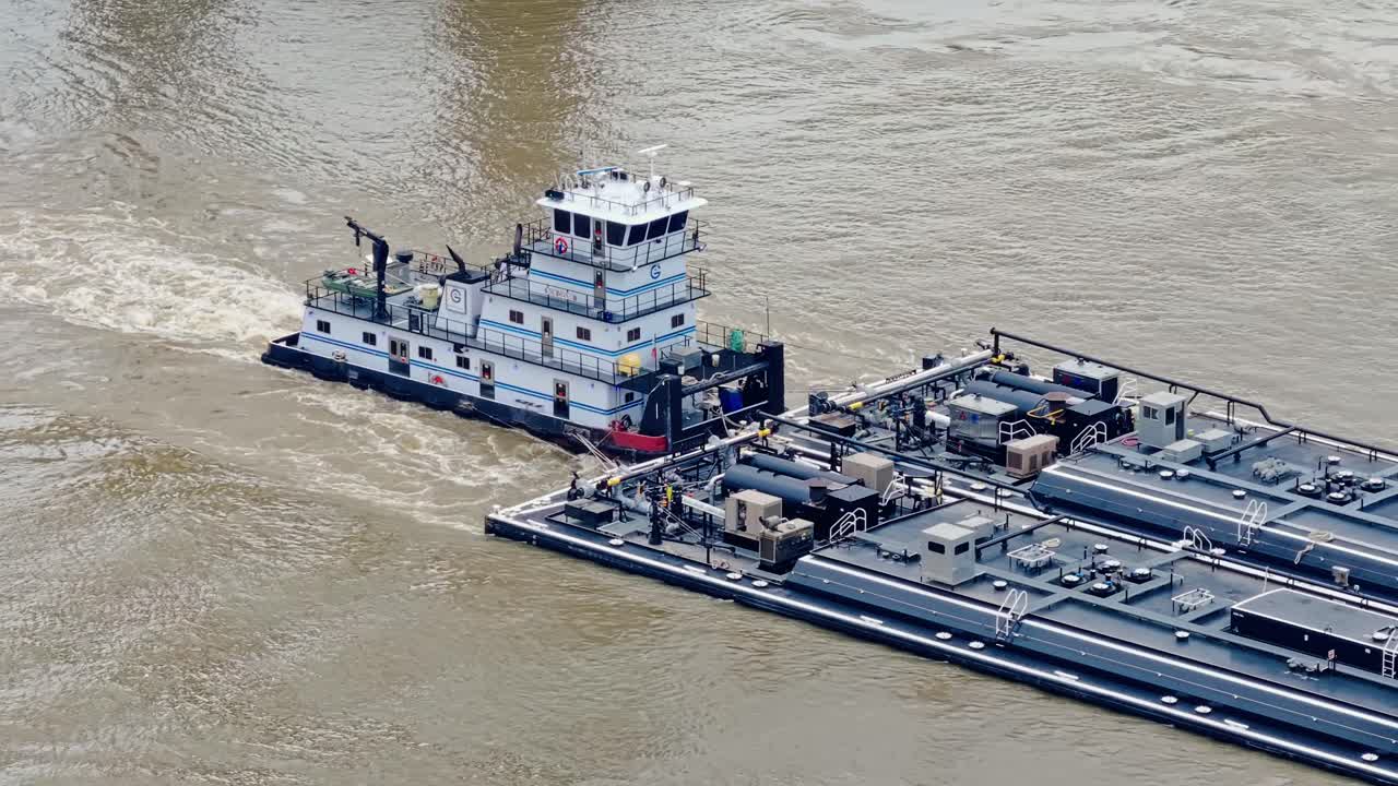 Towboat Pushes Barge In Mississippi River In New Orleans, Louisiana, USA. - aerial shot