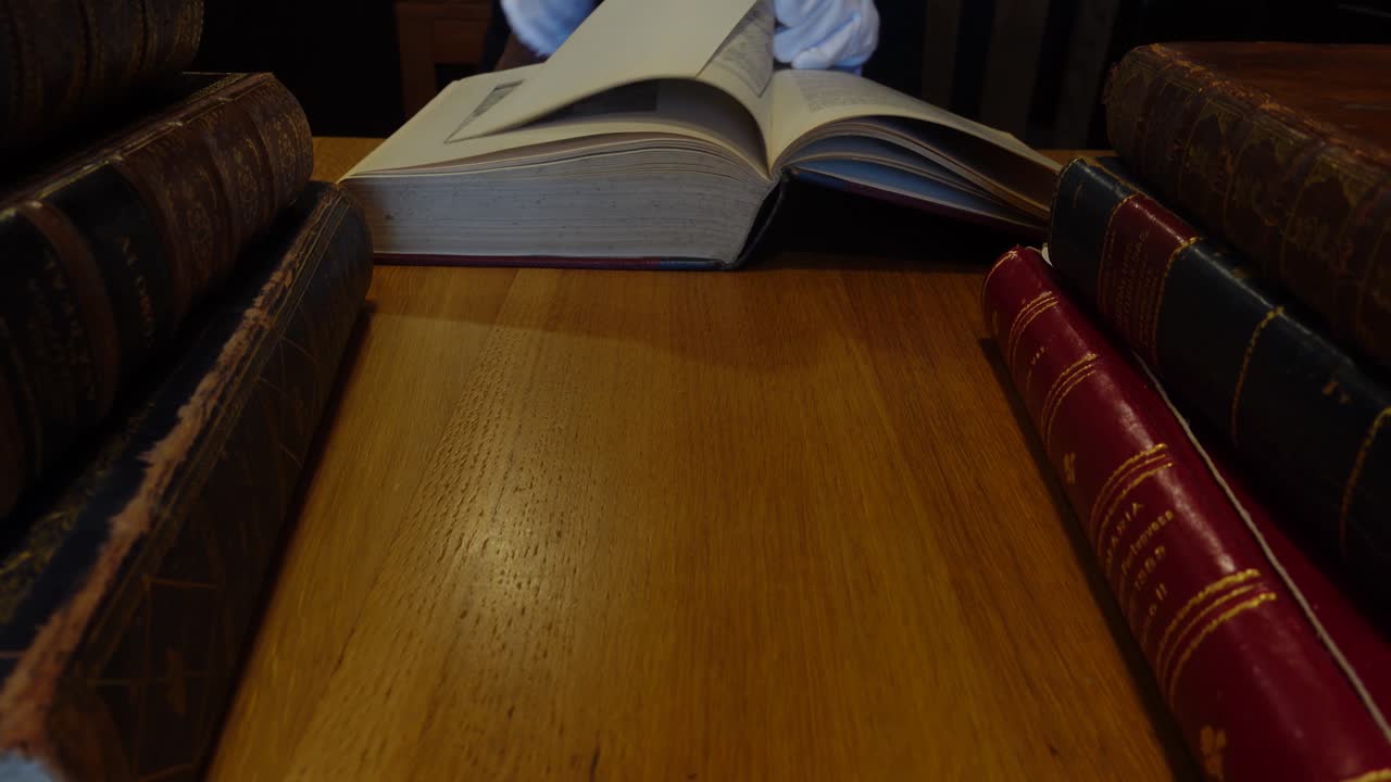 Man's hands leafing through an old book in the library