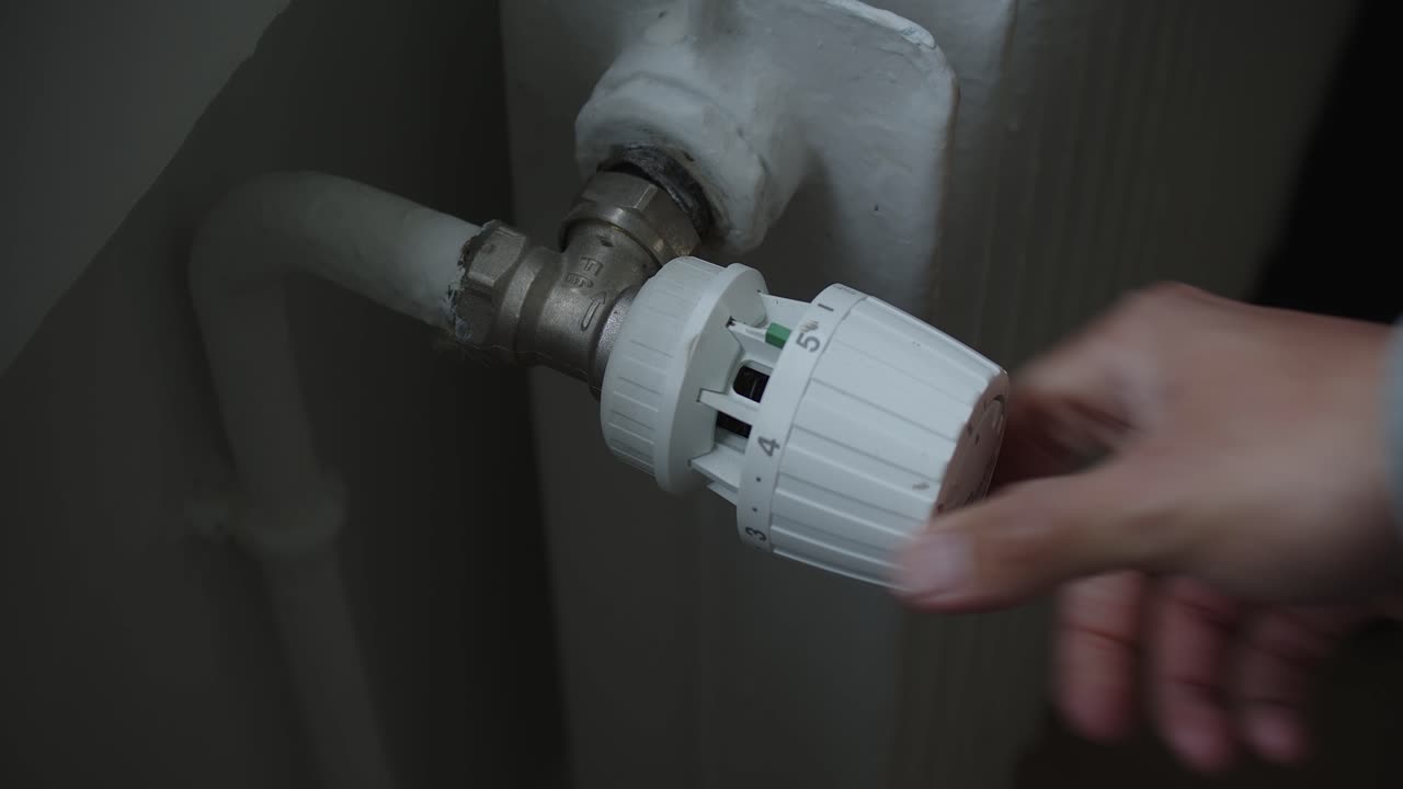 subir a mano el termostato de un radiador a la temperatura máxima, primer plano