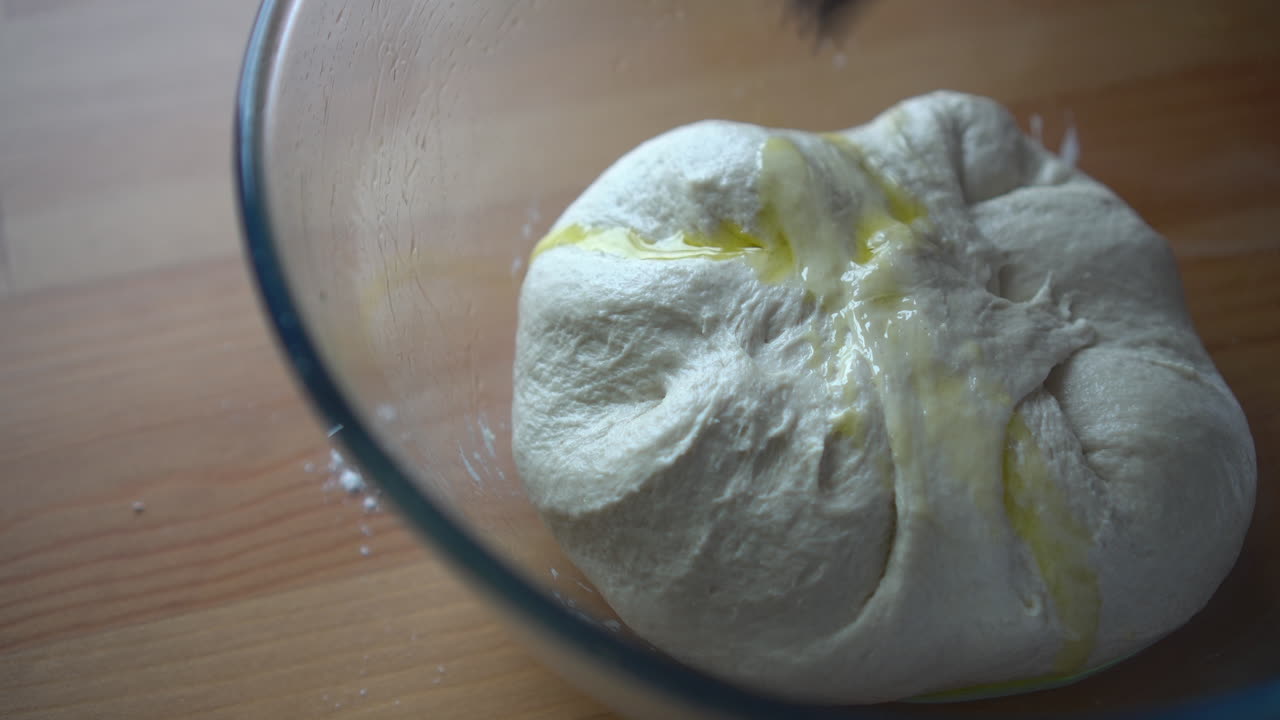 Brushing oil on dough for pizza or bread