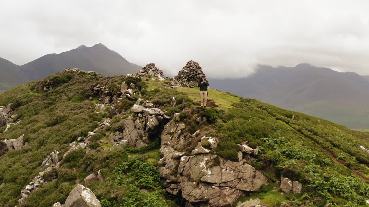 Man on rock formations at Struicín-Strickeen Mountain, Dunloe Upper, Gap of Dunloe, Co. Kerry, Ireland.