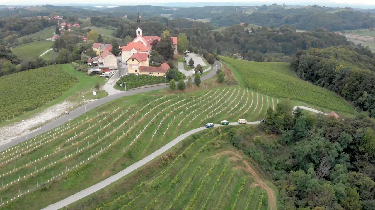 Cars and vans driving through the wine region of Jeruzelum in Slovenia from an aerial perspective