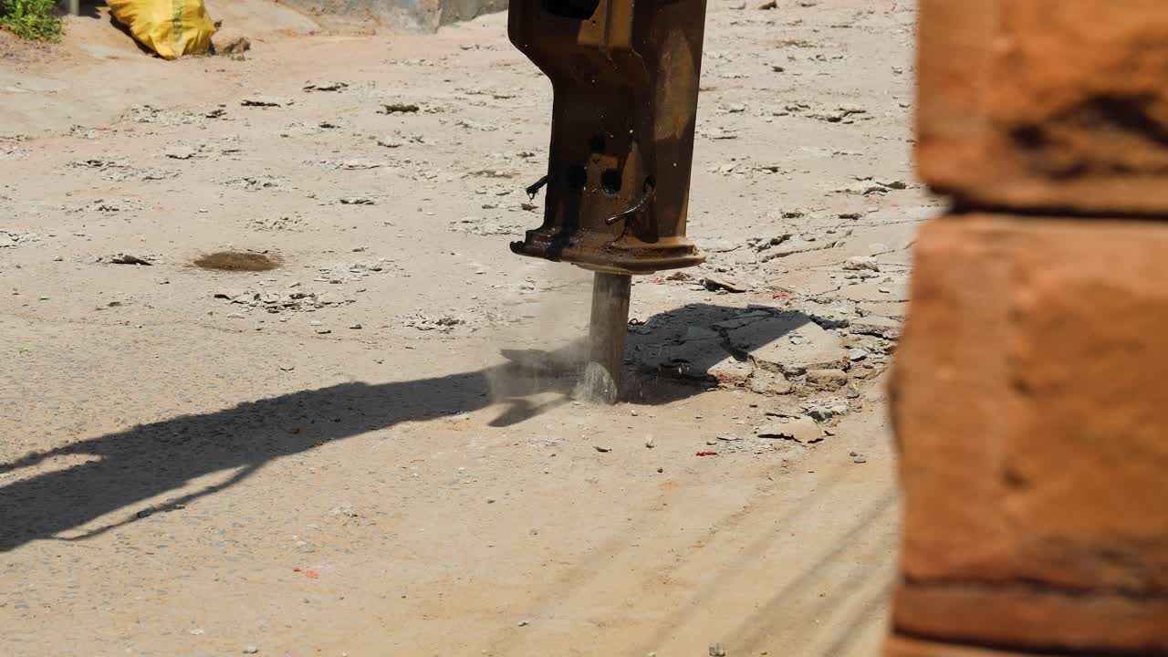 road construction work with excavator breaking pavement
