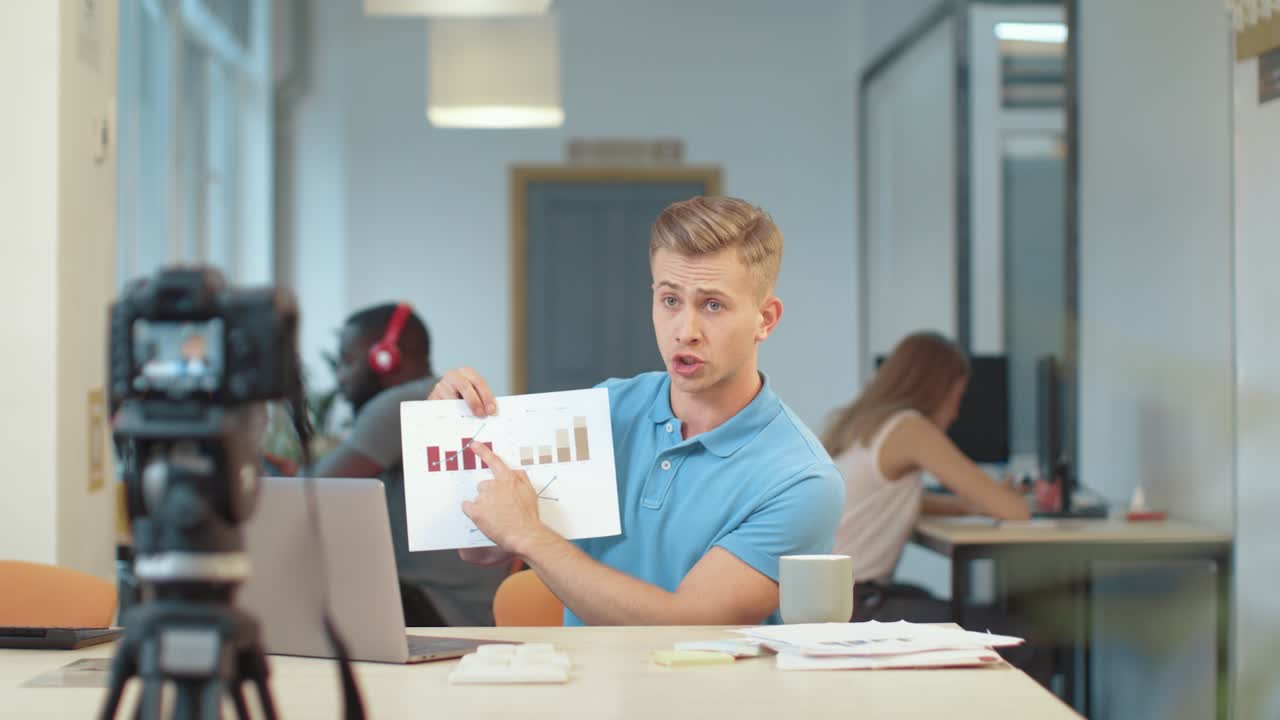 бизнесмен, записывающий презентацию на камеру. серьезный влоггер, представляющий результат