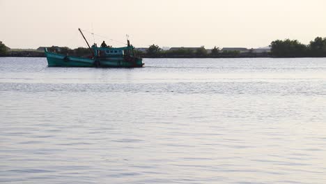 Khmer-fishing-boat-heading-out-to-sea-in-Kampot-Cambodia-that-shows-the-authentic-life,-livelihood-and-culture-of-the-Cambodian-people