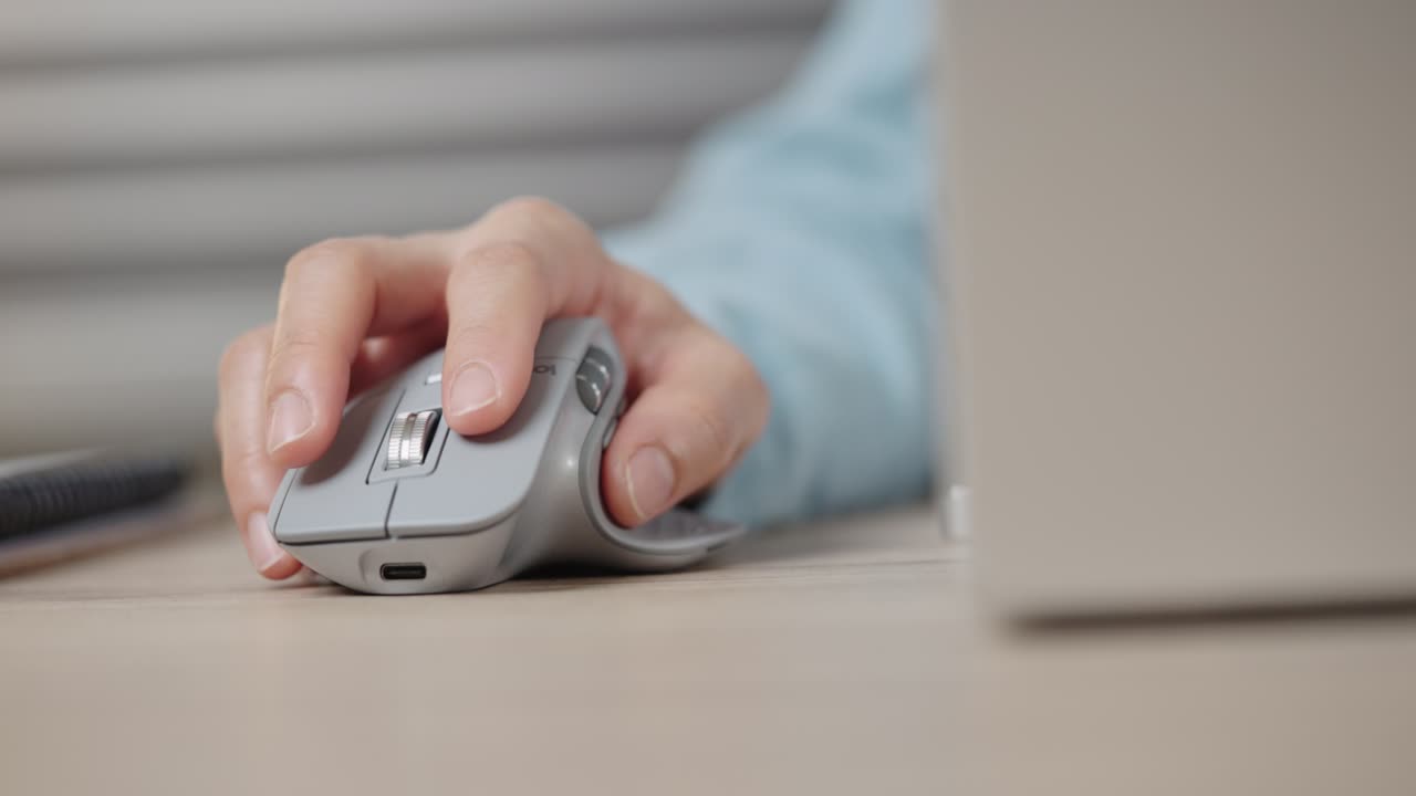 крупный план руки бизнесмена с помощью беспроводной или bluetooth мыши. прокрутка колеса работает с компьютером или ноутбуком.